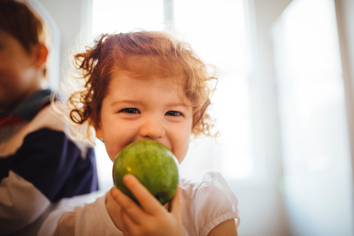 Little girl eating apple 